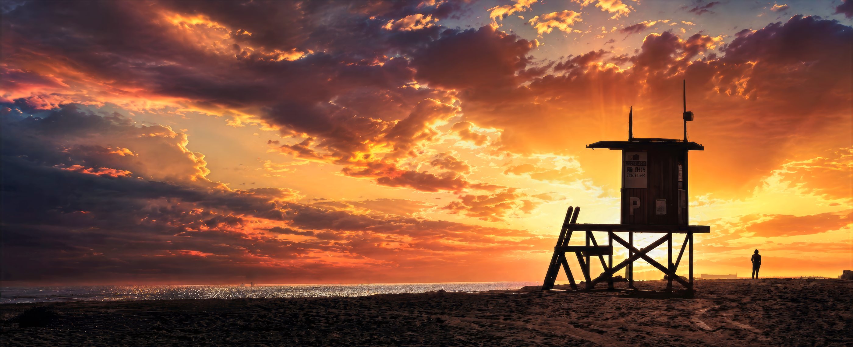 A lifeguard tower in silhouette under a dramatic winter sunset, Newport Beach